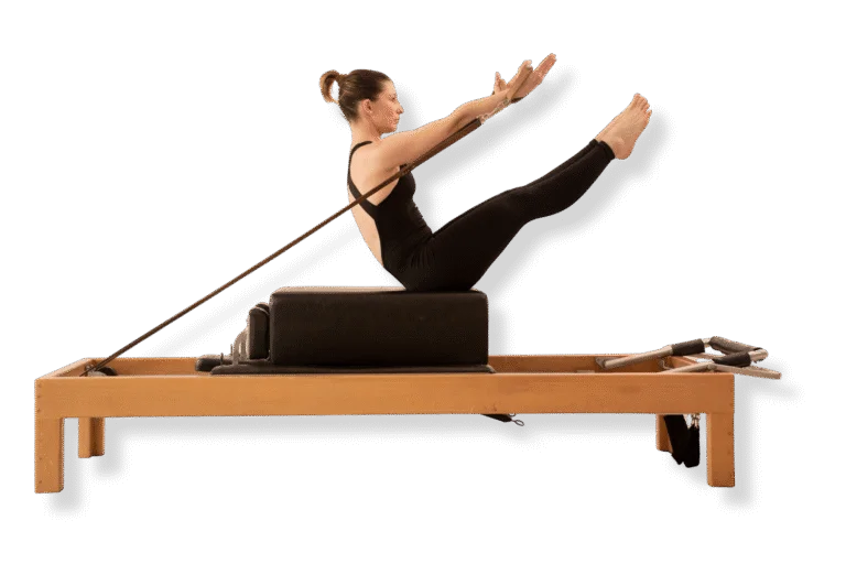 Practicante de Pilates en posición teaser sobre un reformer